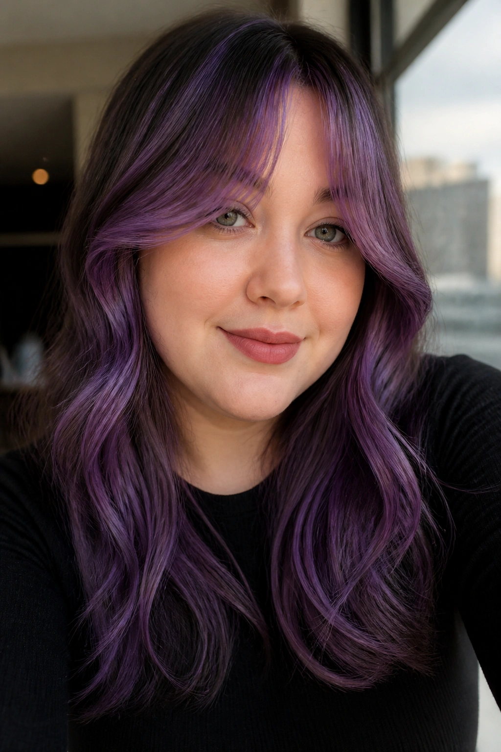 Close-up of a real woman with amethyst curtain bangs framing her round face.