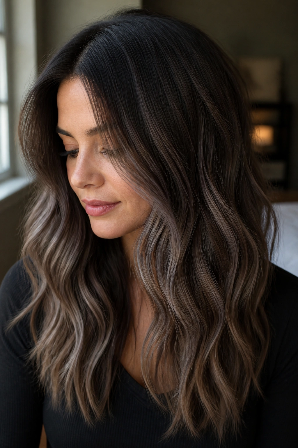 Close-up portrait of a person with dark brown hair showing smoky mushroom ash balayage ribbons and shadowed root