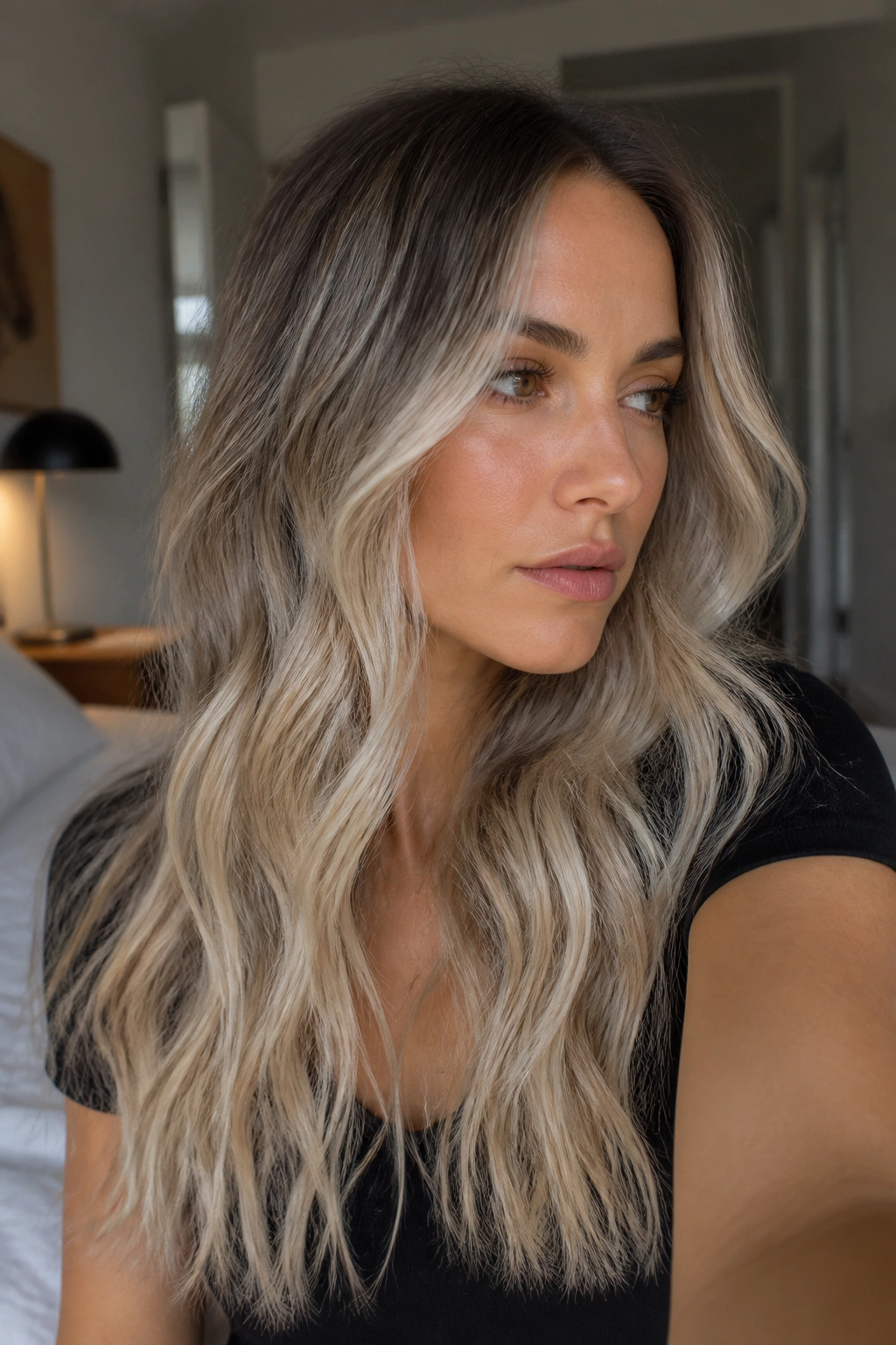 Close-up of a woman with long beach-wave ash blonde ombre hair