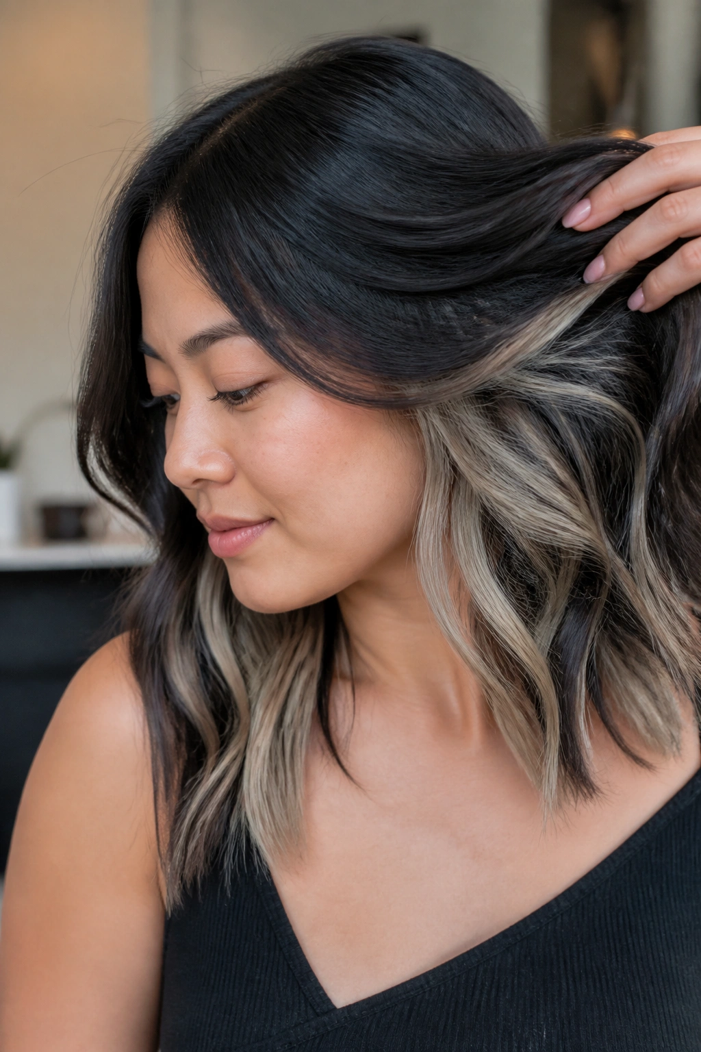 Close-up of ash blonde peekaboo pieces under a dark top layer