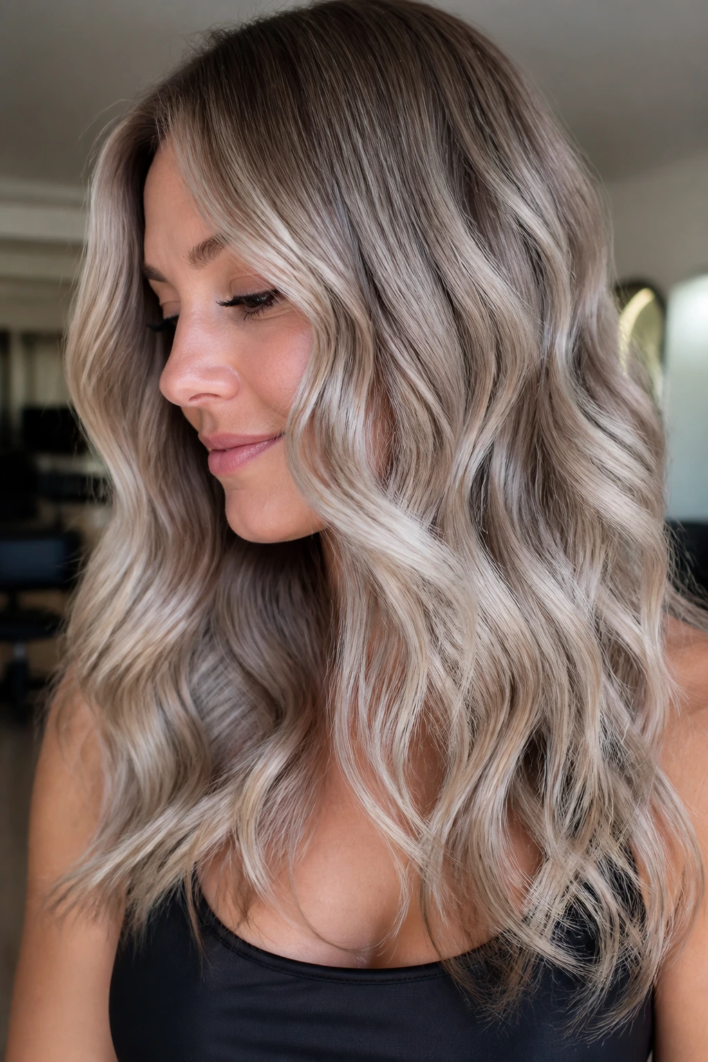 Close-up of a real woman with glossy ash blonde wavy balayage