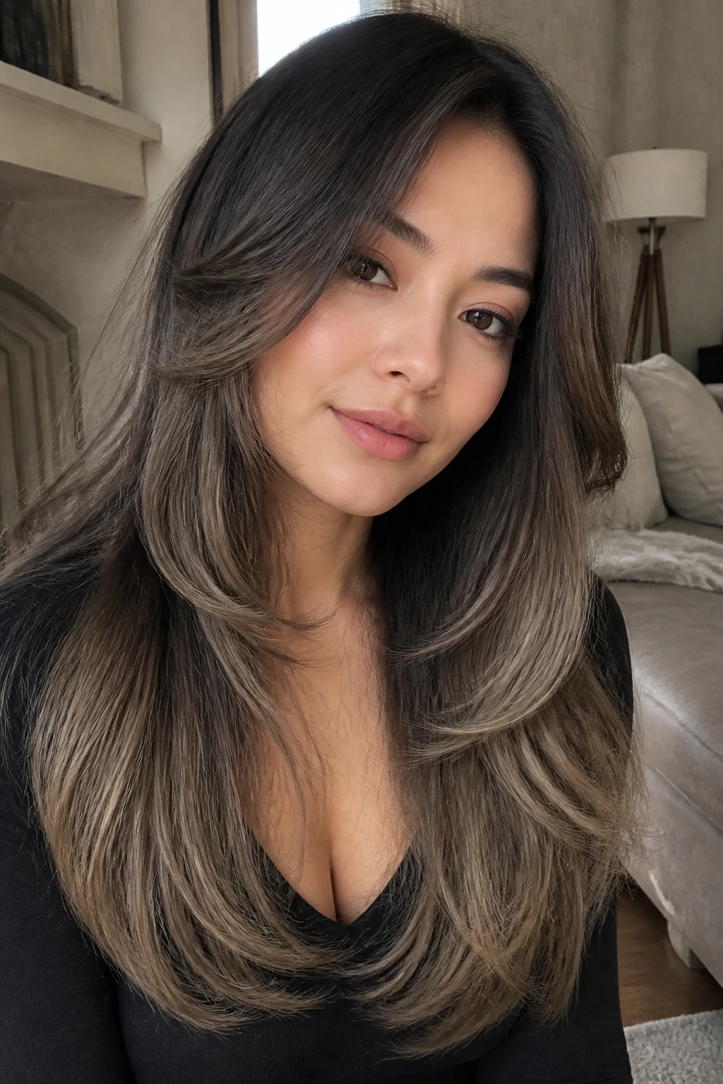Close-up portrait of a real person with long layers and smoky ash brown ends.