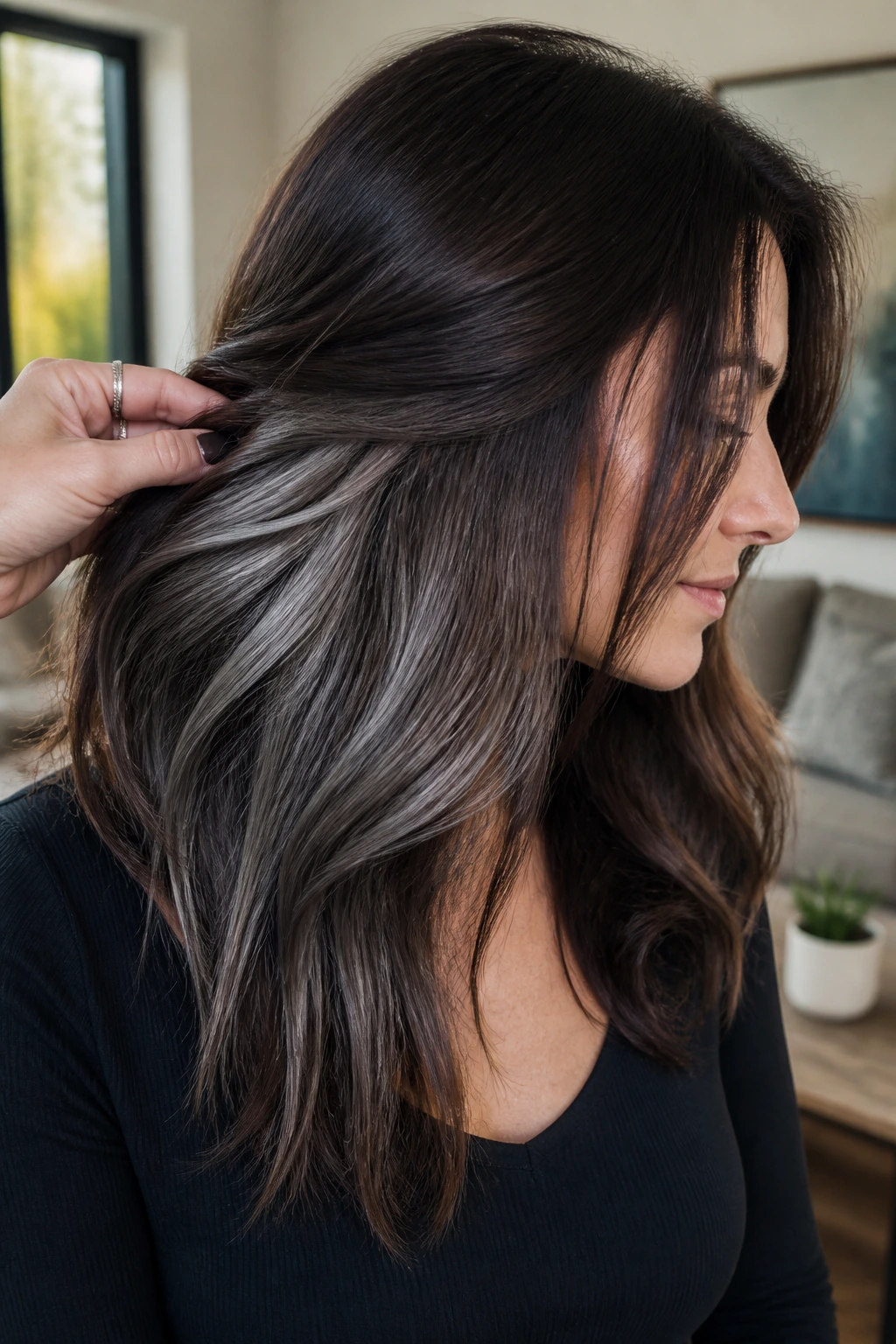 Real woman with ash brown peekaboo balayage under dark layers in natural light