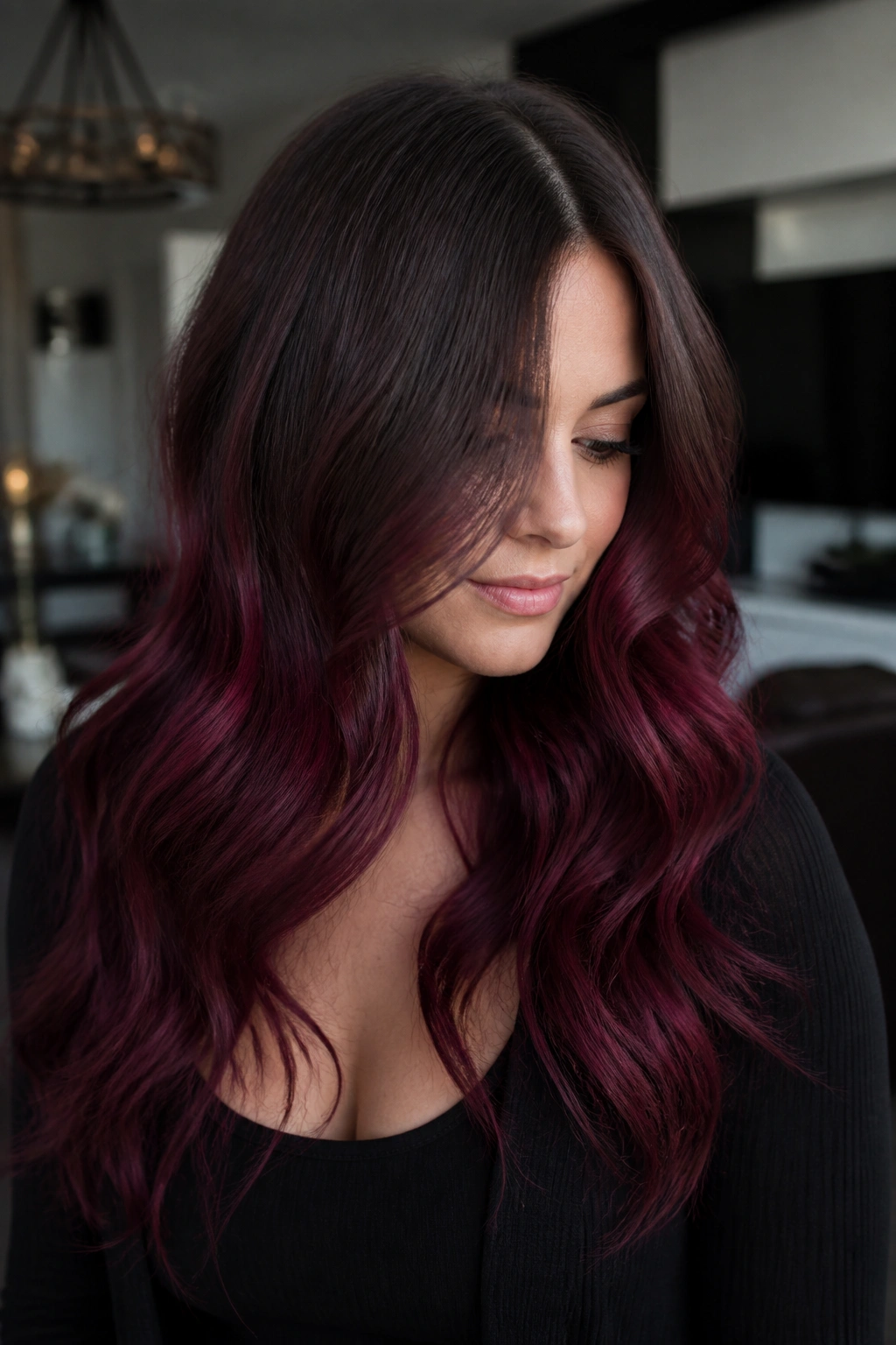 Woman with ash-brown roots and smoky burgundy lengths in cool lighting.