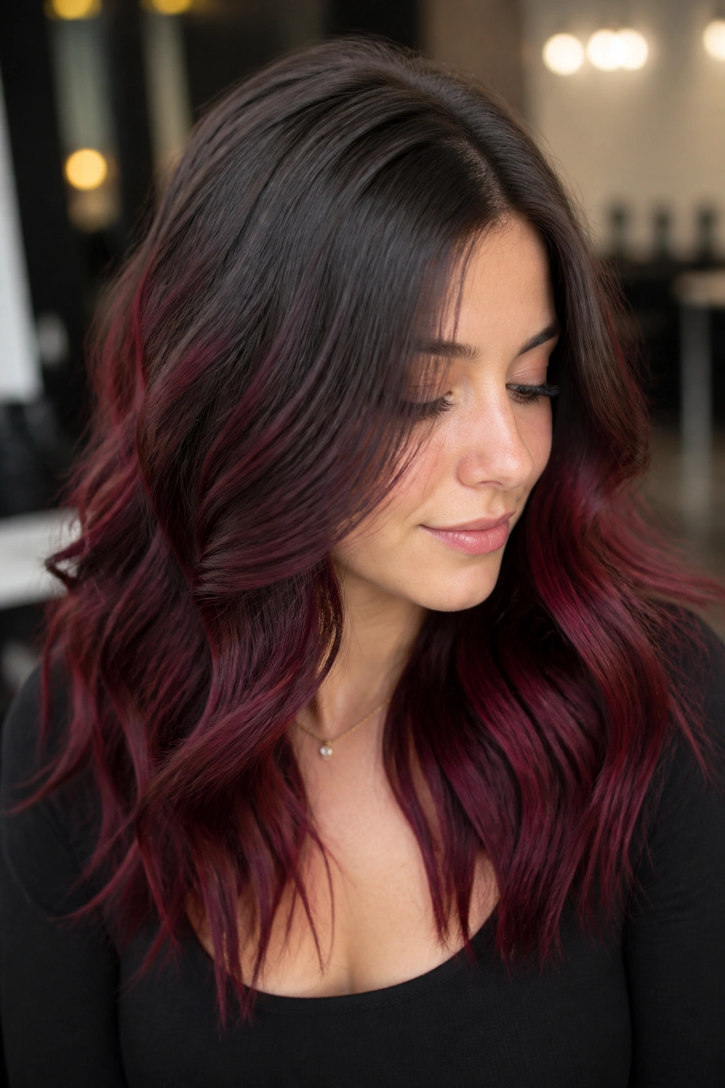 Close-up of ash brown roots transitioning to burgundy melt on real person's hair