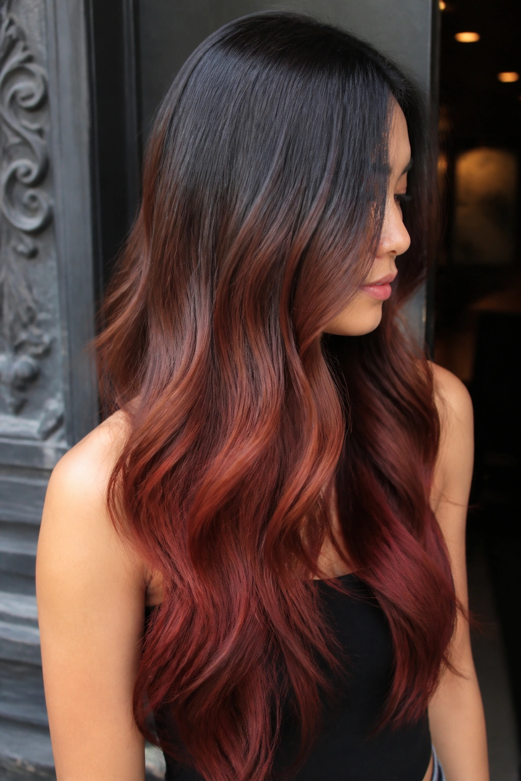 Close-up of long hair showing auburn-to-black color melt from roots to tips.