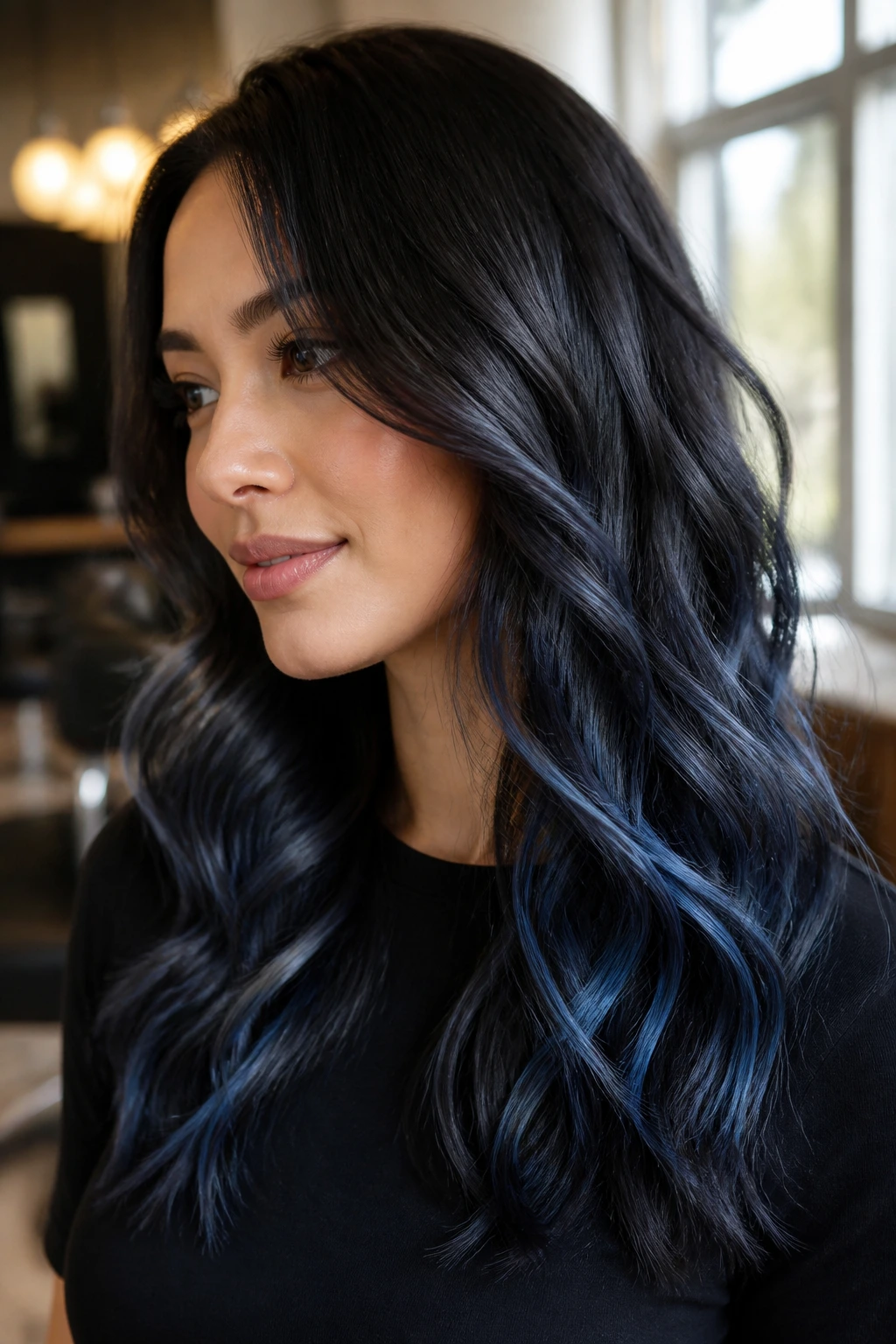 Close-up of a real woman with espresso brown hair showing restrained moonlit blue balayage near mid-lengths and ends
