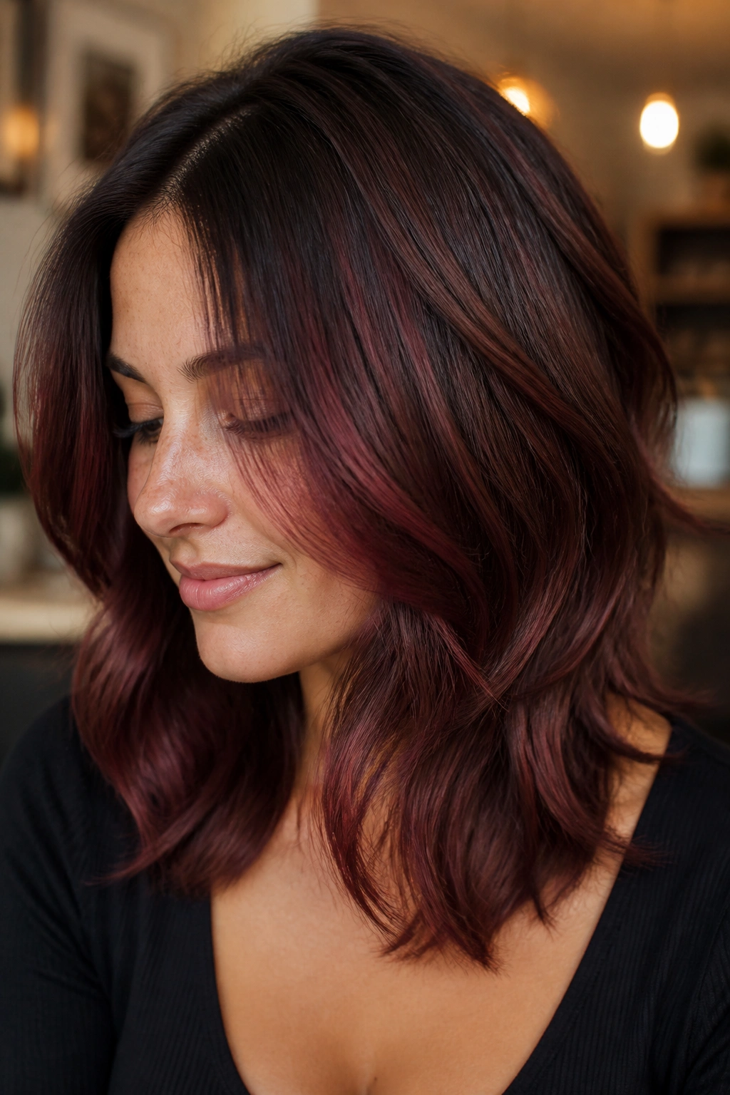Real woman with mahogany melt hair transitioning from soft brown roots to wine-toned mid-lengths.