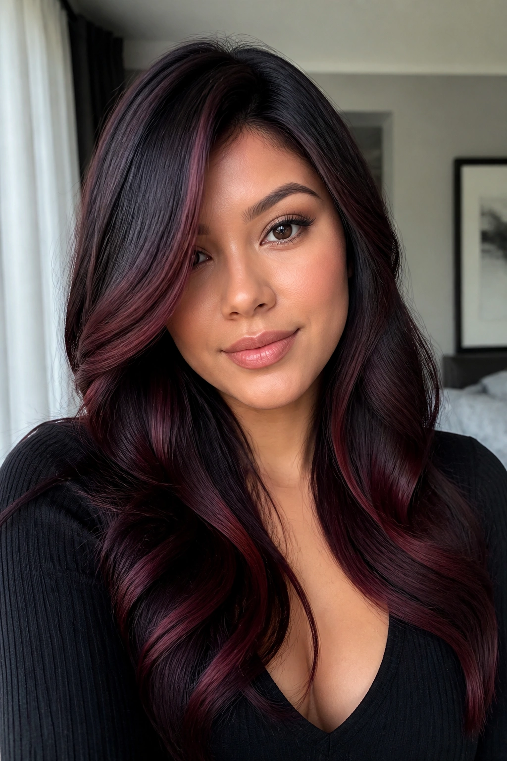 Close-up of real woman's hair with black cherry balayage off-center part