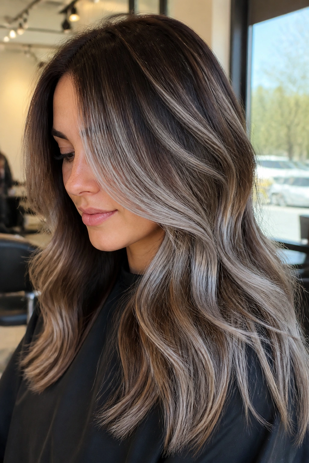 Close-up portrait of a real woman with bronzed brown base and silver overlay balayage.