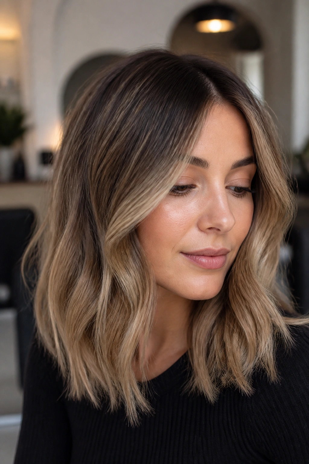 Close-up of beige caramel with shadow roots on cool-toned brunette hair