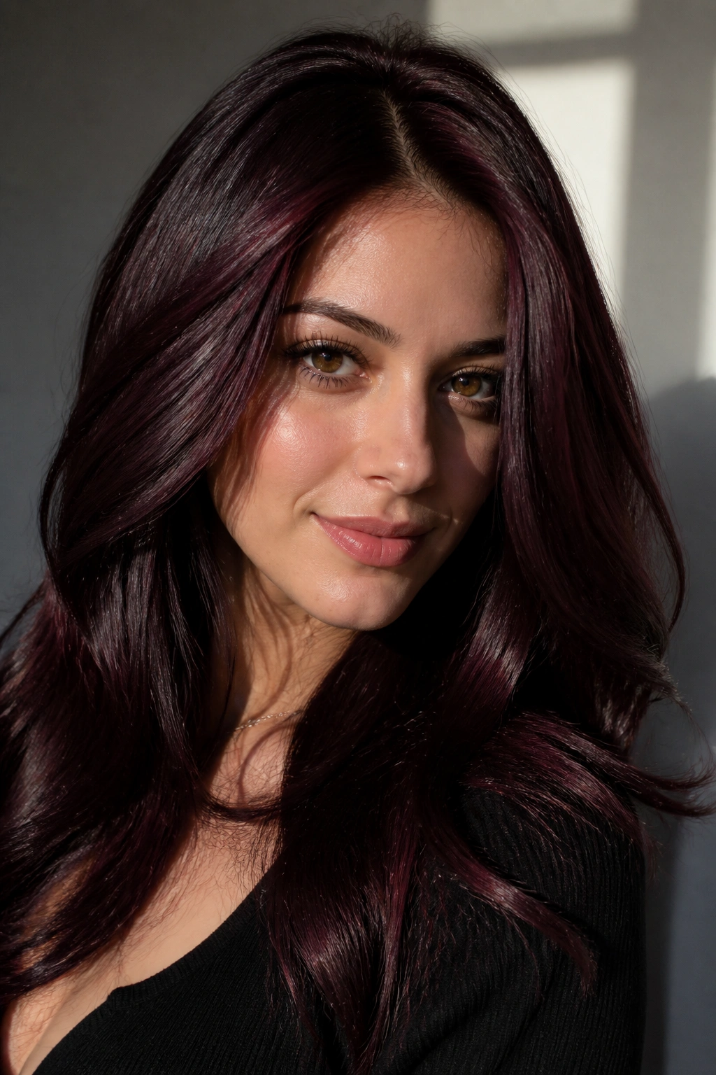 Close-up portrait of a real person with Black Cherry Mahogany hair showing a glossy burgundy sheen