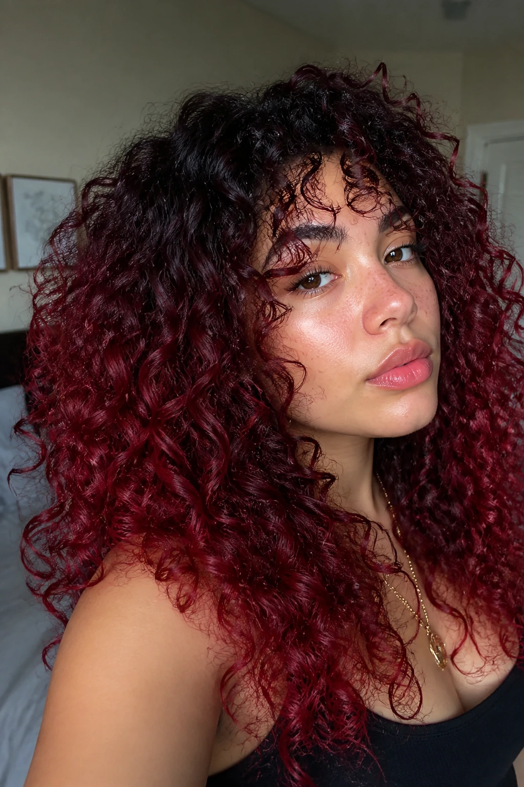 Portrait of a person with a dark root and cherry red hair