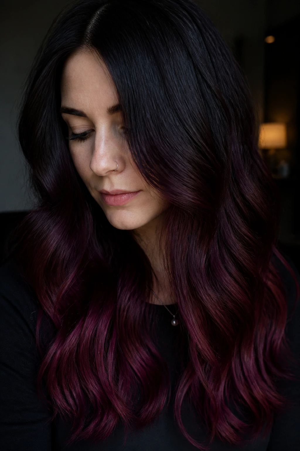 Close-up of a real woman with dark base hair and cherry-violet ends in soft waves