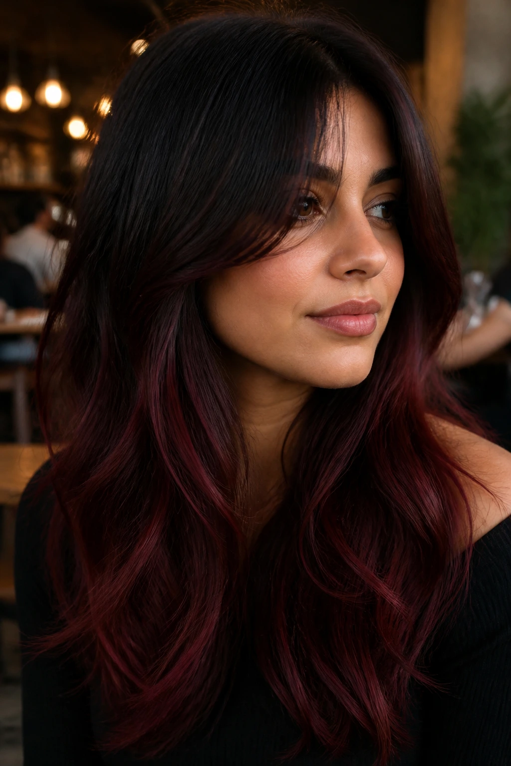 Close-up portrait of a person with black to dark red ombre and curtain bangs