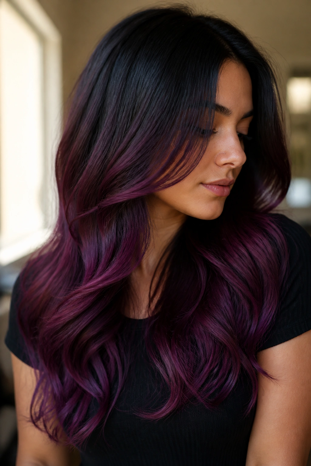 Close-up of a real woman with long black-to-plum/eggplant ombre hair