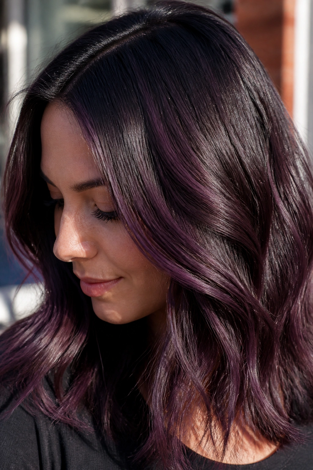 Close-up of blackberry balayage on dark brown hair with purple sheen
