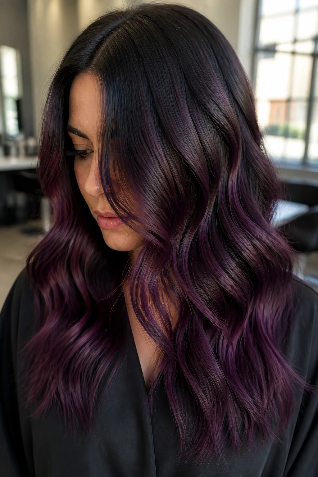 Brunette with blackberry balayage and cool brown root in a close-up portrait