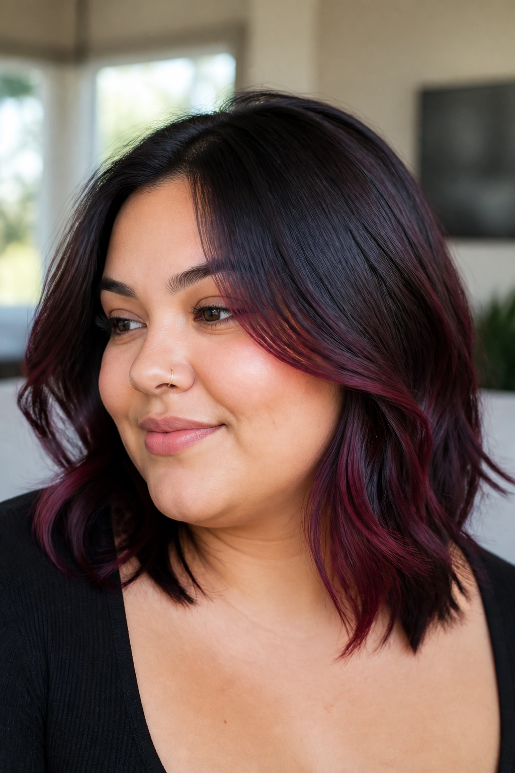 Portrait of a woman with mid-length hair featuring blackened raspberry highlights