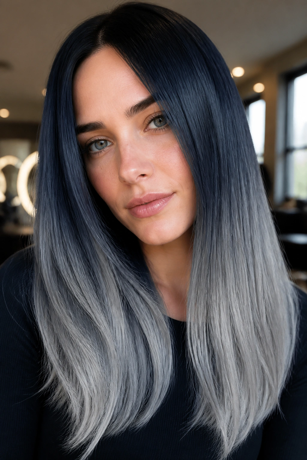 Close-up of a woman with blue-black hair and silver ends in glossy finish.