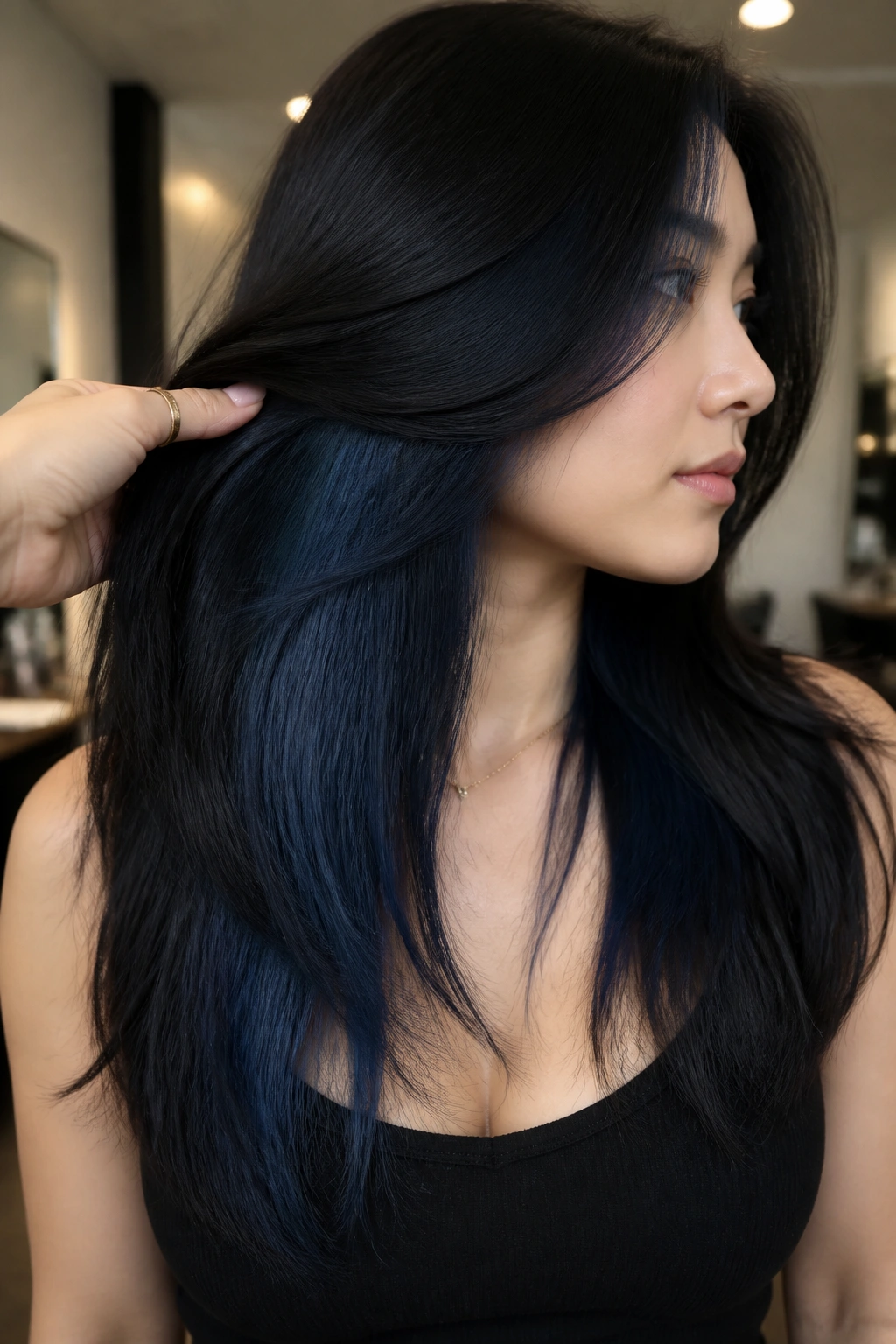 Real person with hidden blue-black underlights visible under sleek top layer in salon