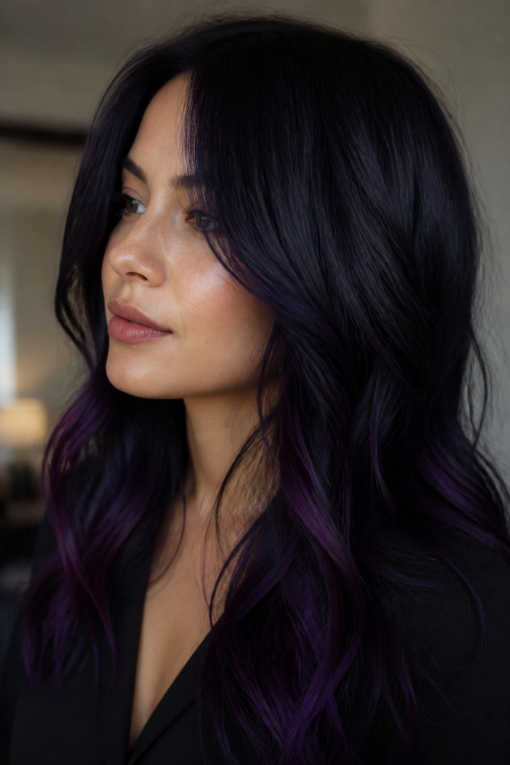 Close-up of blue-black hair with violet undertones on a real person indoors.