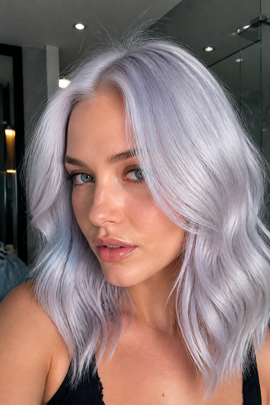 Close-up of a woman with blue-violet gloss platinum giving a glassy icy blonde on cool skin