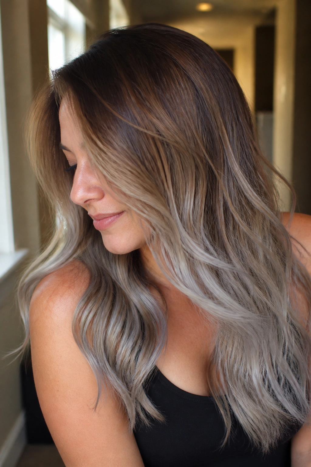 Close-up of brunette hair with bronze roots fading into silver ends on a real person