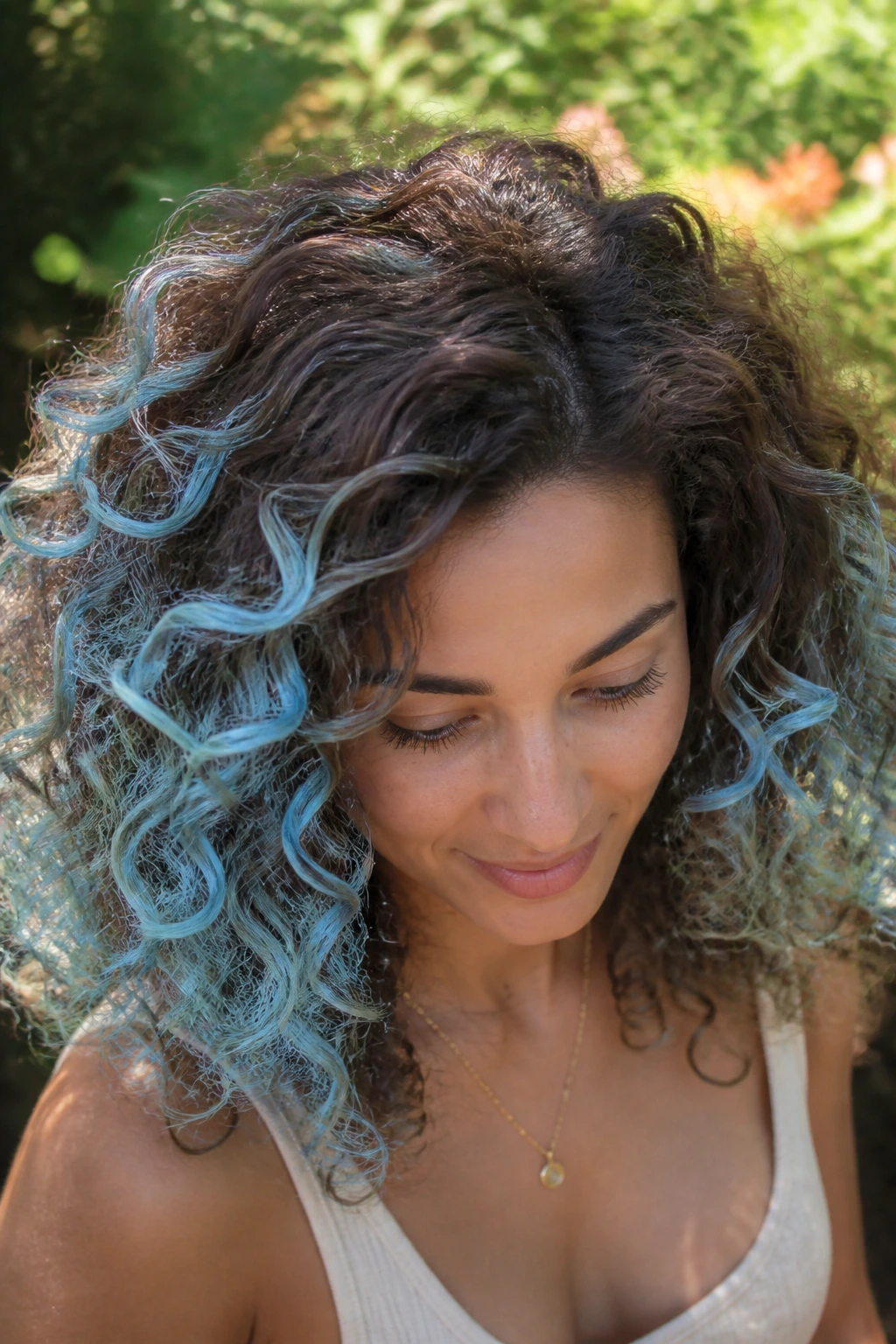 Close-up of a real woman with brown curls and sky blue halo highlights