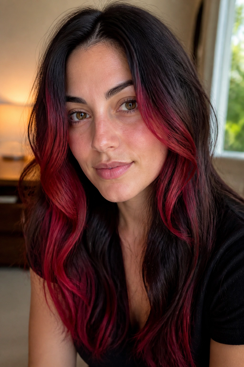 Close-up of a real person with deep brown hair and scarlet face-framing ends.