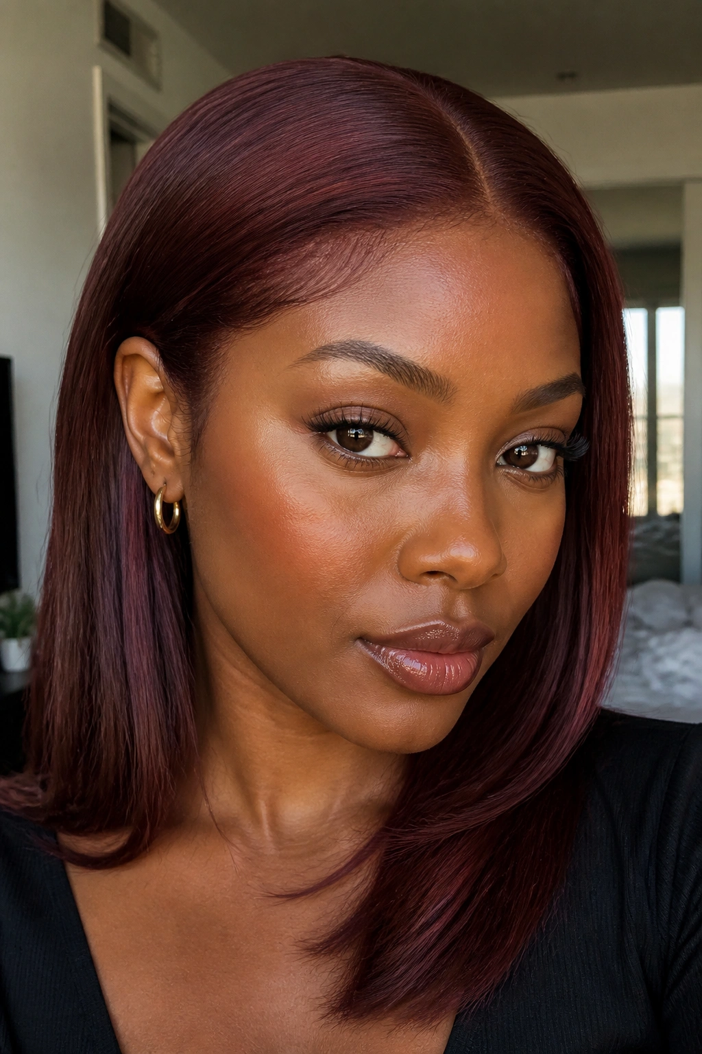 Close-up of burgundy auburn hair on a real person with deeper skin tone