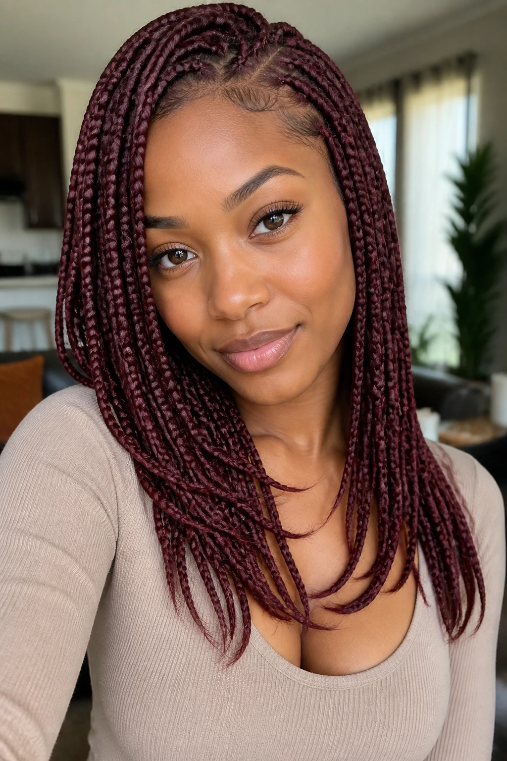 Portrait of a woman with burgundy box braids layered lengths around the face