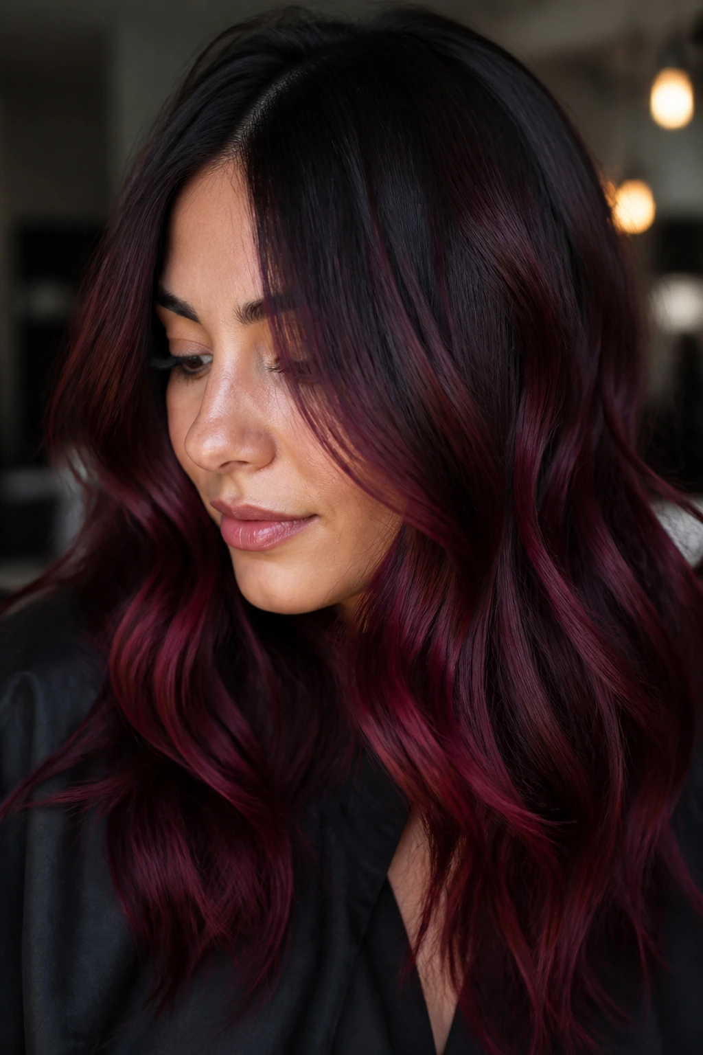 Close-up of a real woman with burgundy cherry melt hair and moody lighting