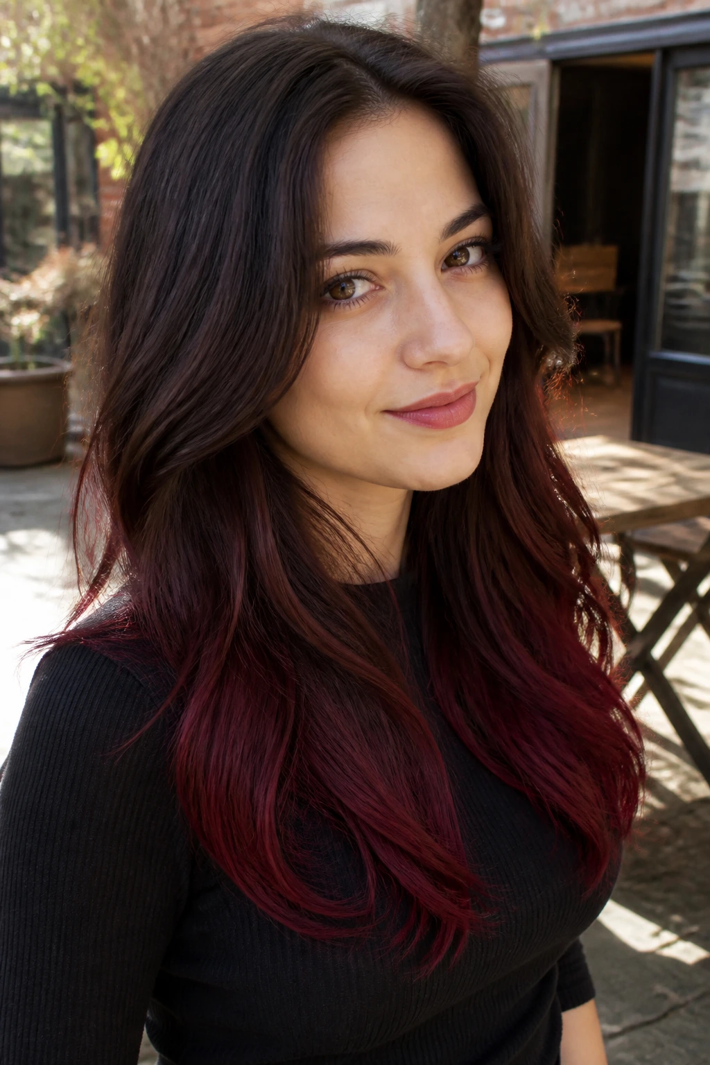 Close-up of a woman with burgundy dip-dyed ends in natural light