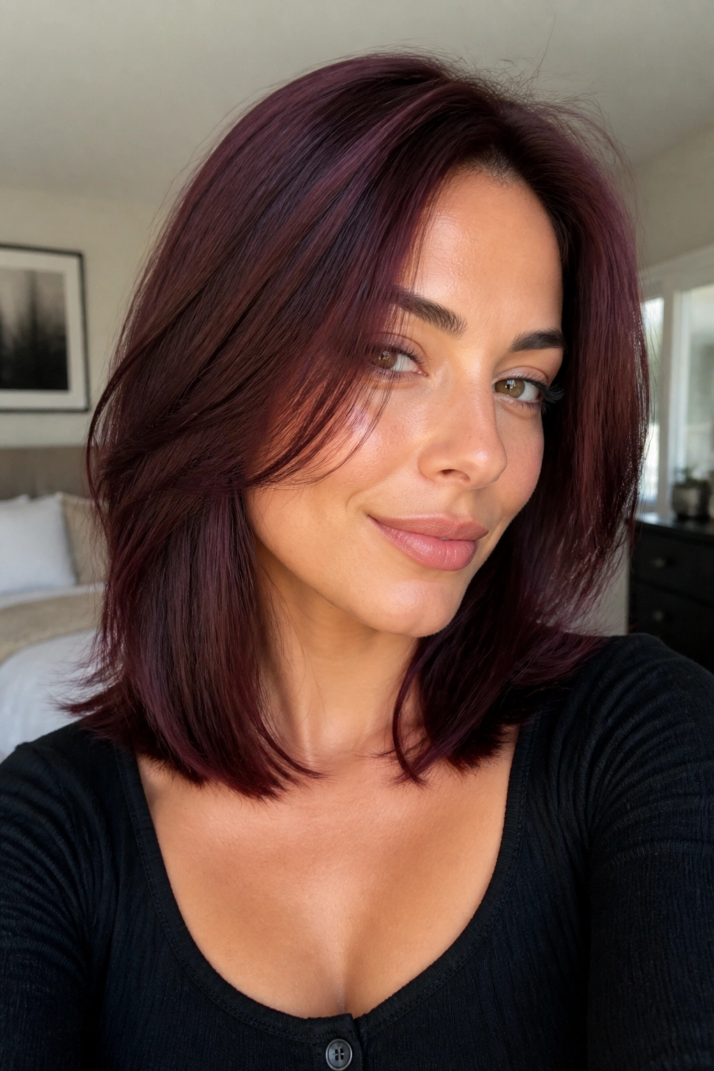 Close-up of a burgundy lob with soft layers on a real woman.