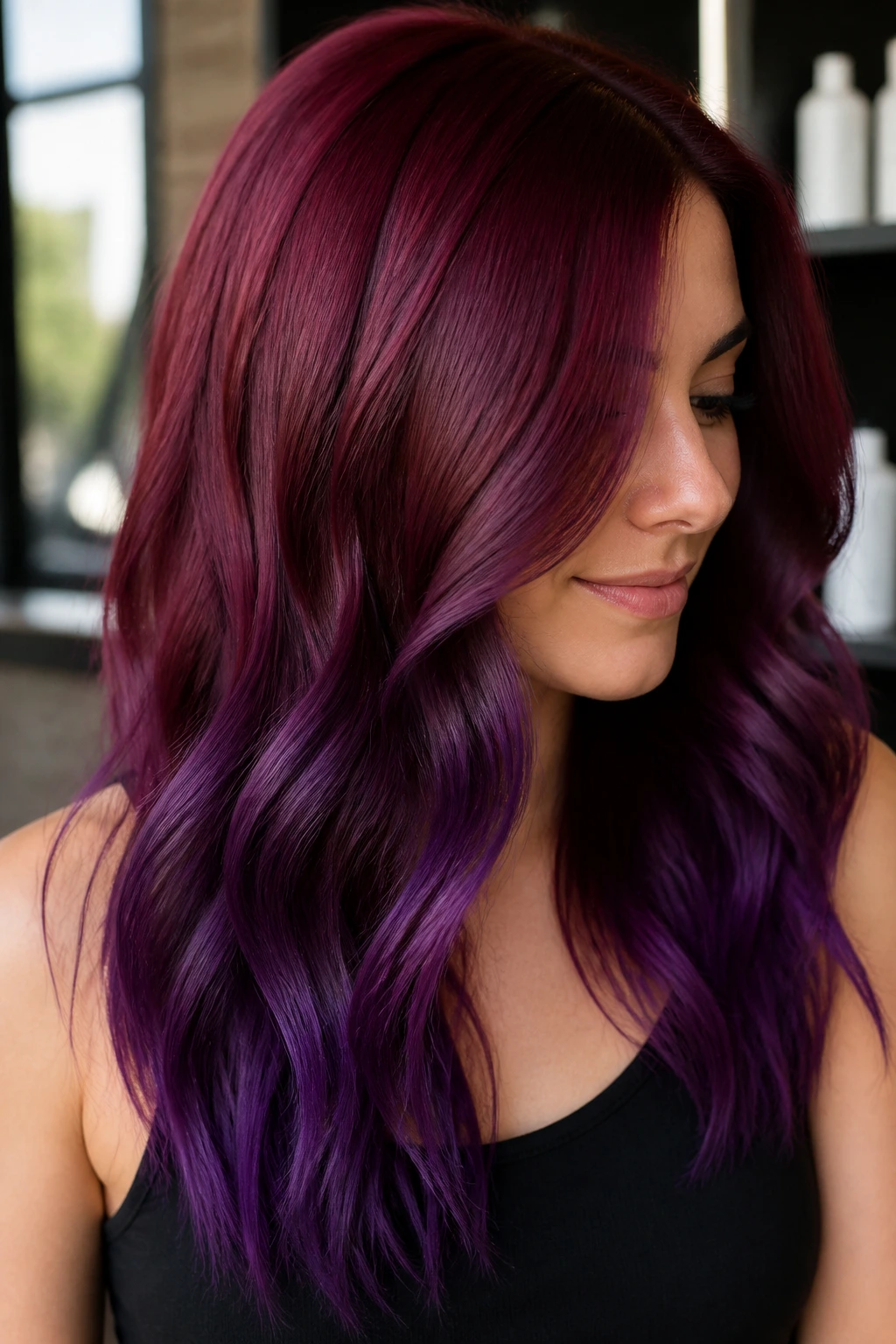 Close-up portrait of a real woman with burgundy roots fading to purple ends in long hair