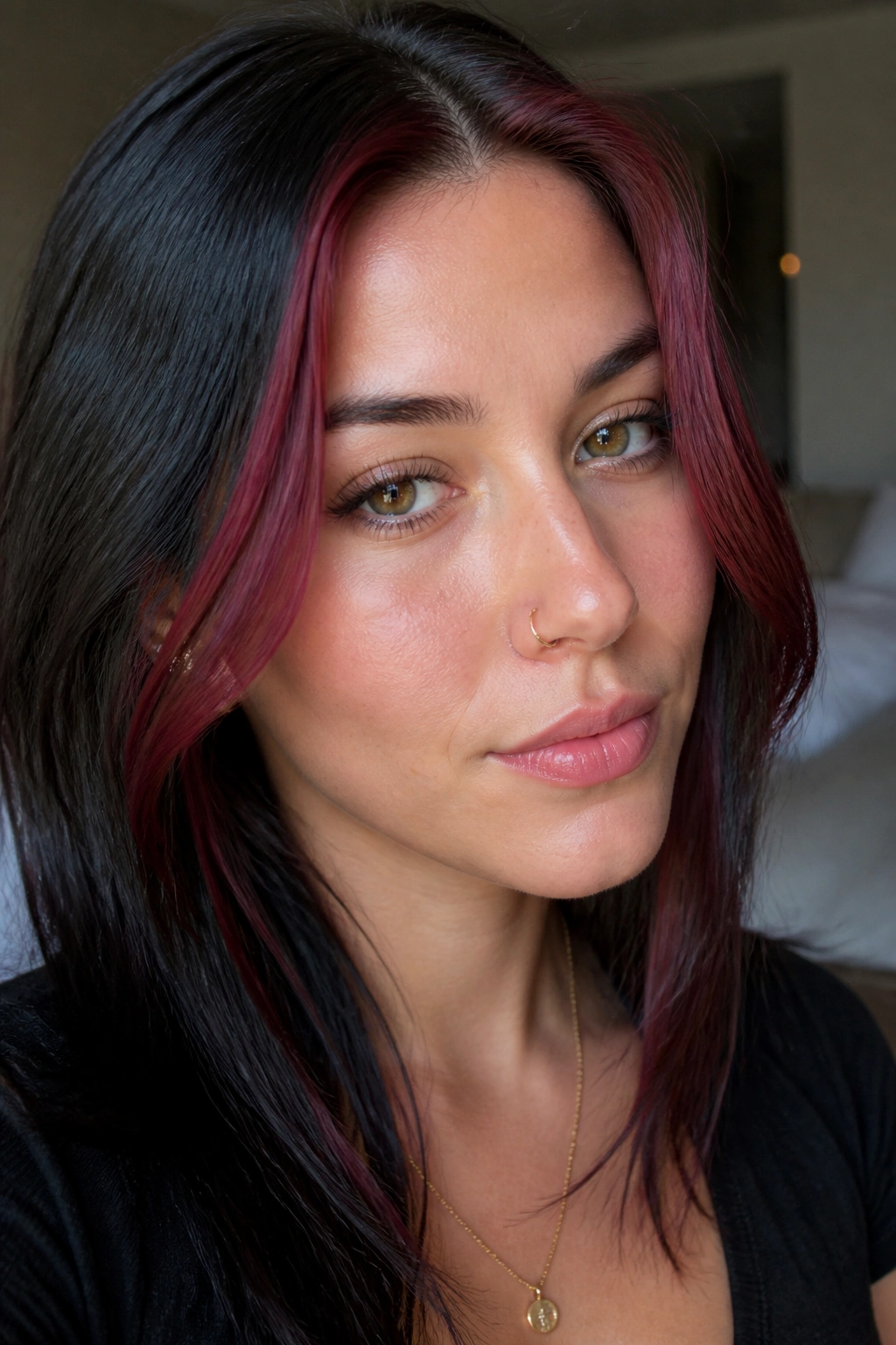 Portrait highlighting burgundy face-framing streaks near the cheeks