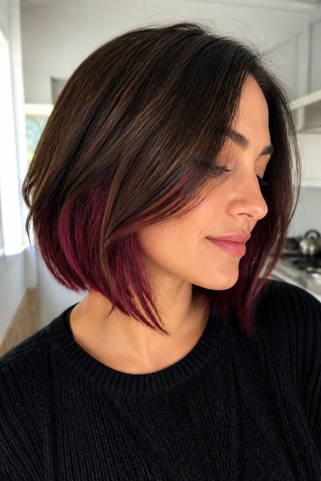 Close-up portrait of a woman with a brown bob showing cabernet peekaboo underlayers
