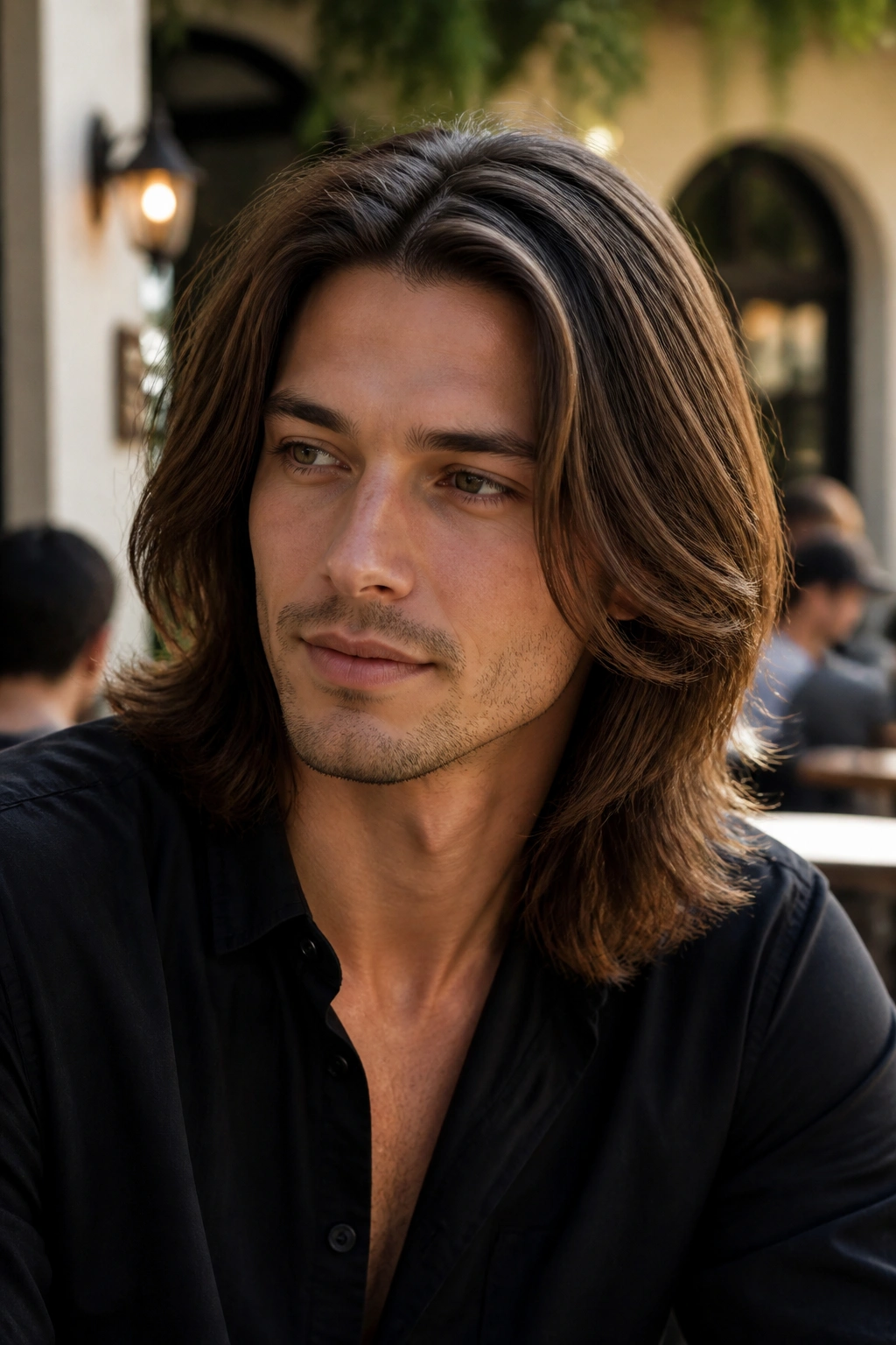 Close-up of a man with long center-parted layered hair in a sunlit cafe
