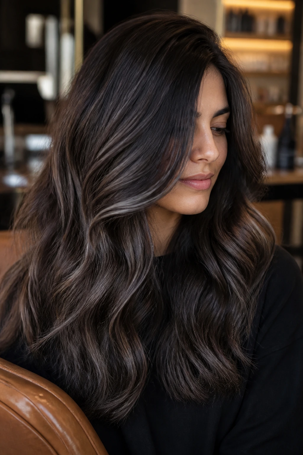 Thick brown hair with charcoal balayage pieces tucked inside layers