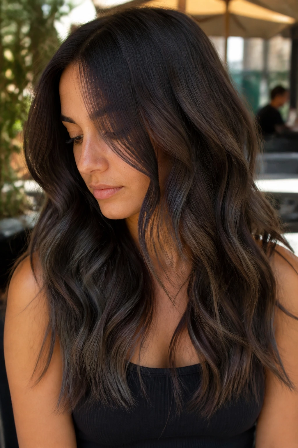 Close-up of chocolate brown hair with irregular charcoal ribbon balayage.