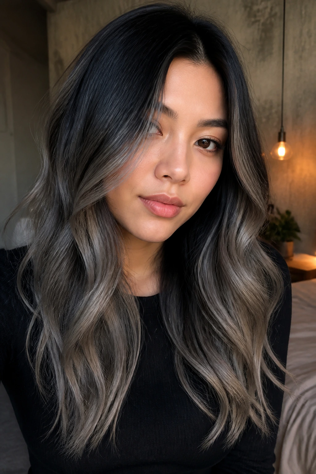 Close-up of a real woman with charcoal transition hair from dark roots to grey ends