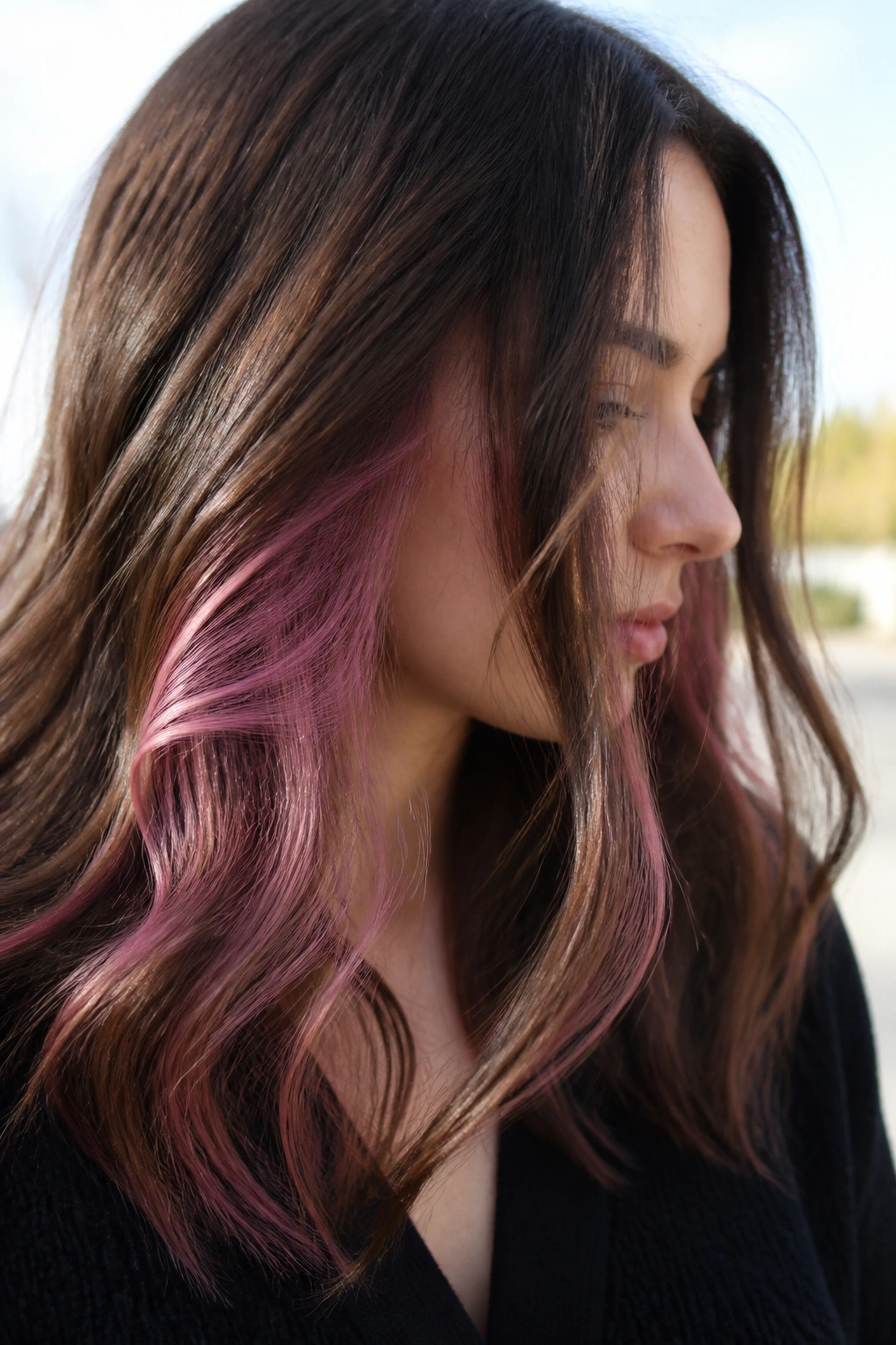 Close-up of brown hair with cherry blossom peekaboo layers on a real woman.