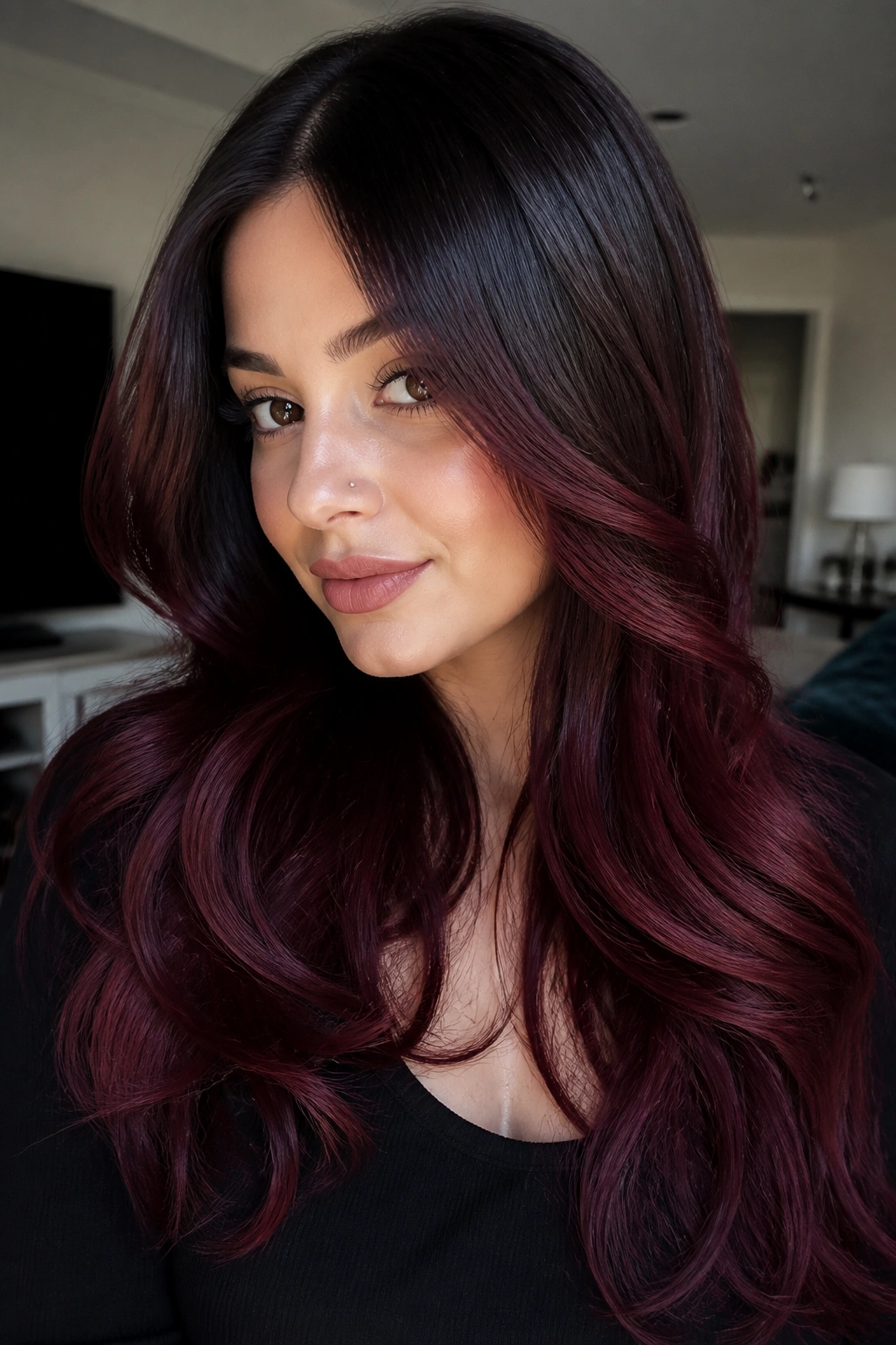 Real woman with cherry cola melt hair gradient from dark roots to burgundy ends.