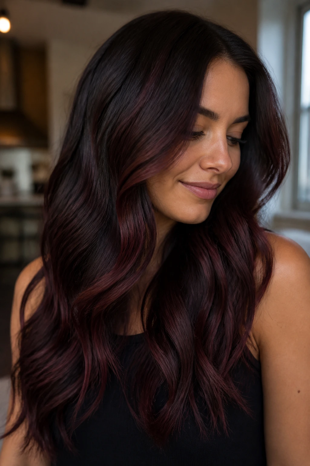 Close-up of a real person showing dark brown hair with cherry cola highlights, glossy and dimensional