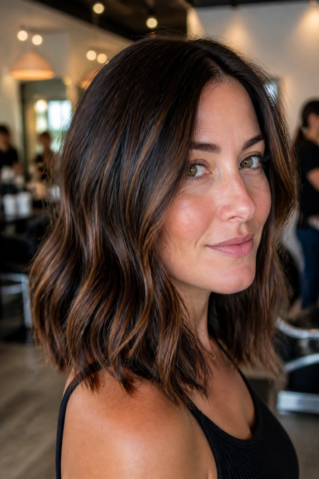 Close-up portrait of a woman with chestnut babylights over a dark brown base.