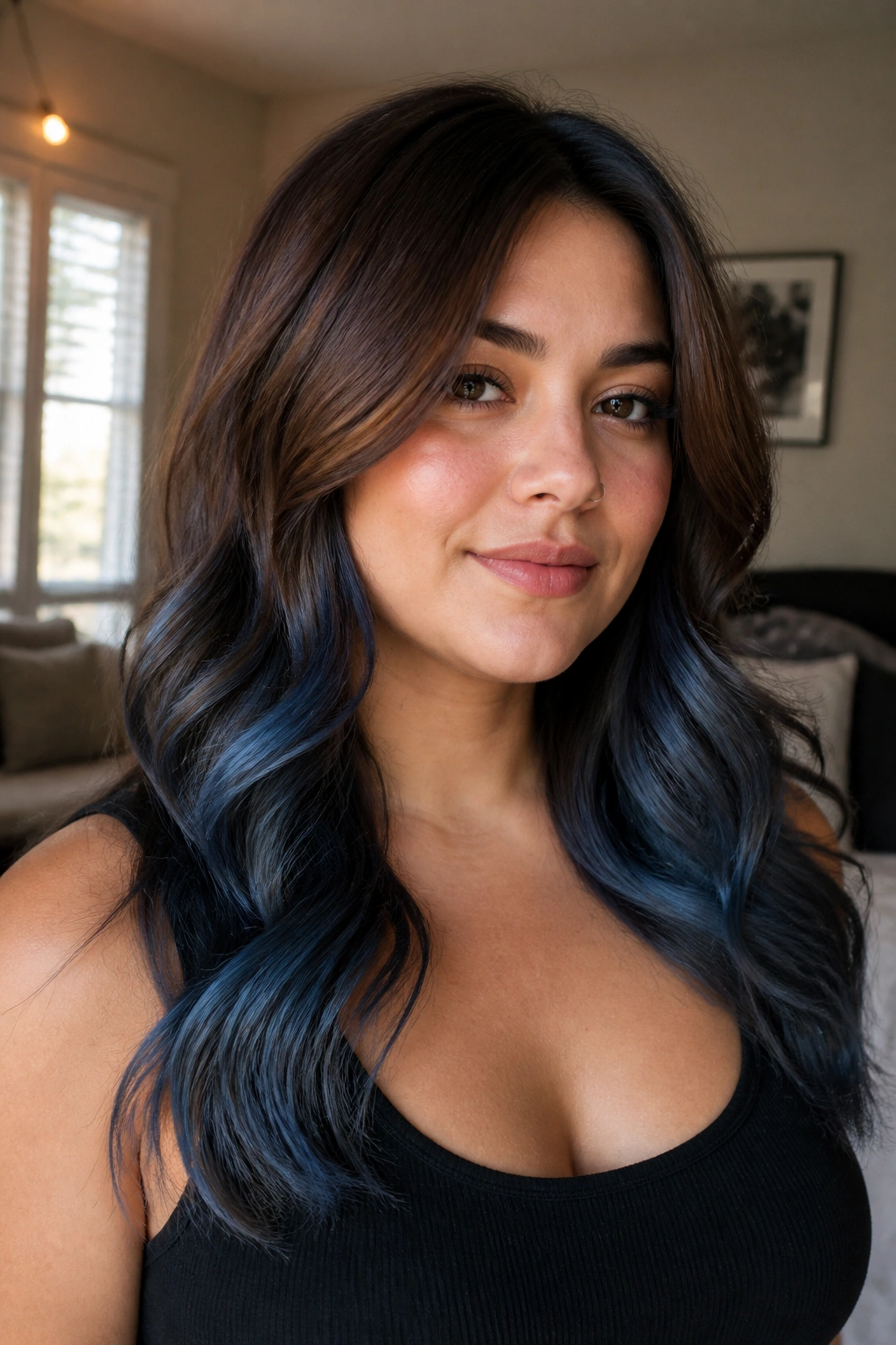 Portrait of a real person with chestnut brown hair and denim blue balayage from mid-length to ends.