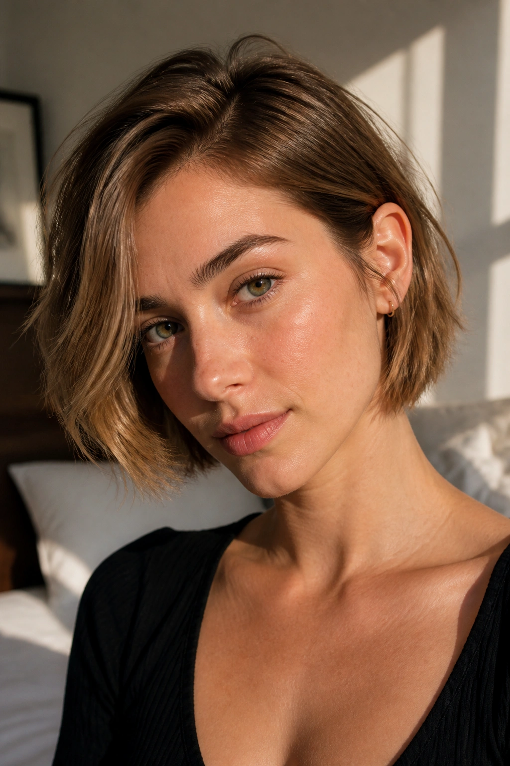 Close-up of a real woman with a chin-length textured bob and soft ends under natural window light.