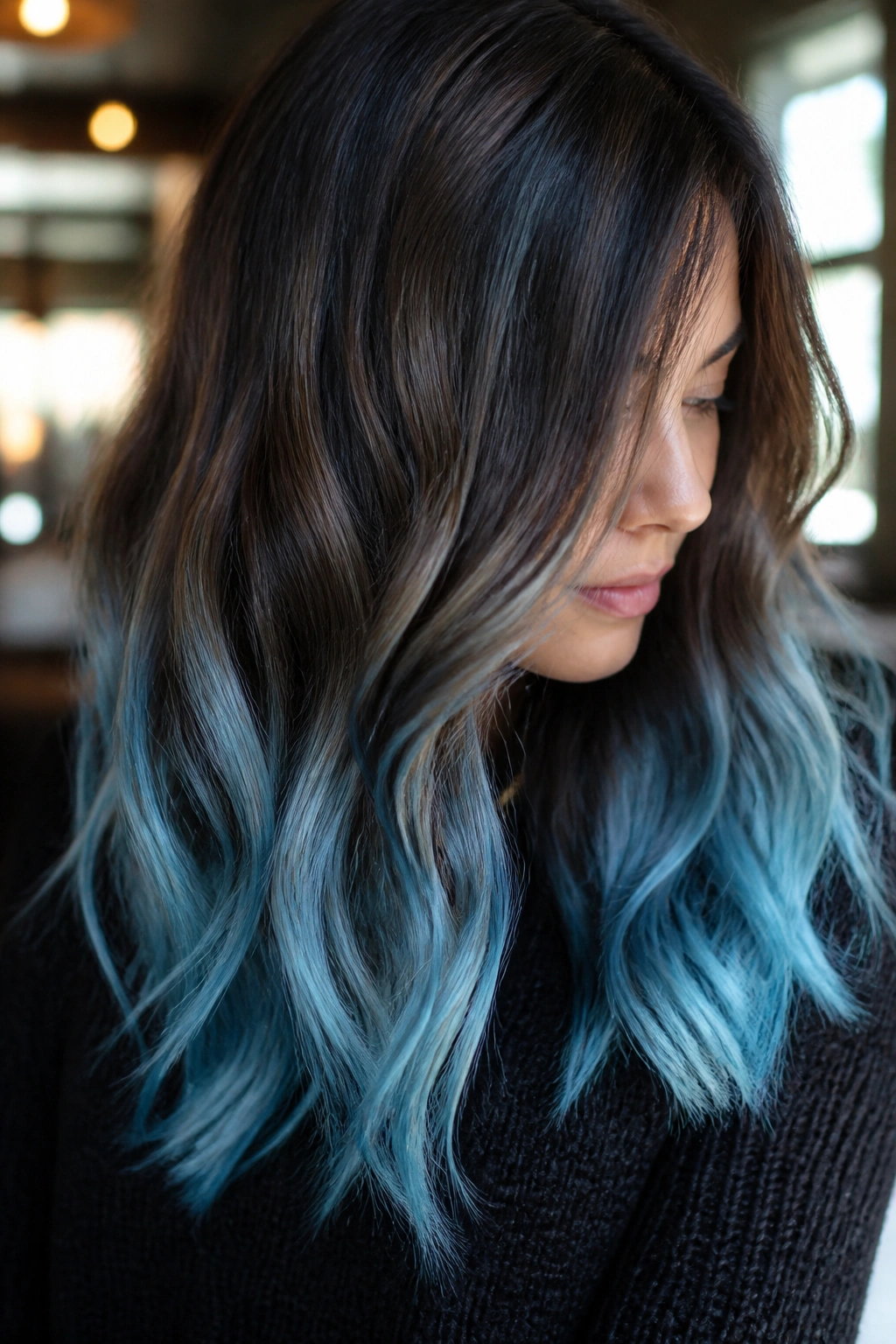 Close-up of chocolate balayage with icy blue ends on brown hair.