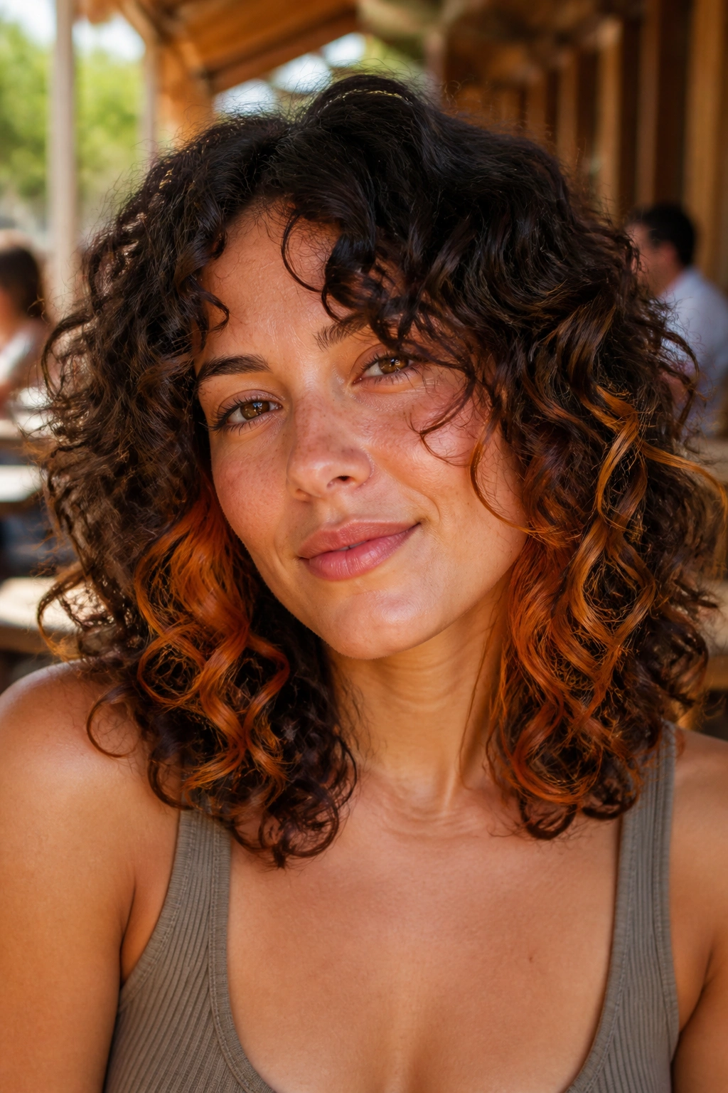 Close-up of a real woman with cinnamon peekaboo under curls around the ears